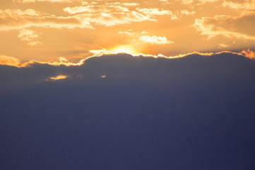 The sky at sunset with a large dark cloud below_