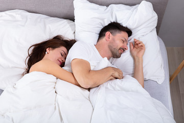 Couple Sleeping On Bed With Blanket