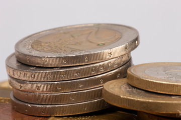 Euro coins stacked on each other in different positions. Selective focus