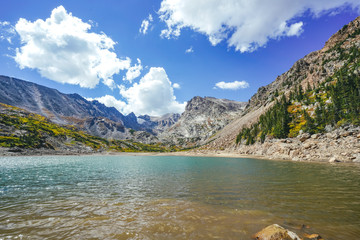 Naklejka na ściany i meble Alpine Lake with Beautiful Snowy Mountains, Blue Sky, and Clouds in the Colorado Rocky Mountains