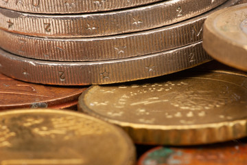 Euro coins stacked on each other in different positions. Selective focus