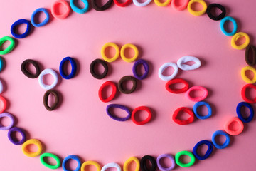 The word Yes in the form of multi-colored hair elastics, placed in an oval