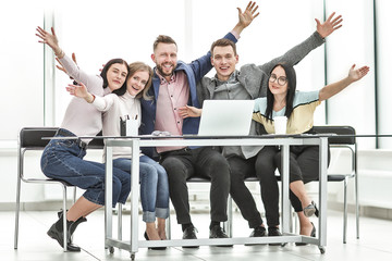 group of happy employees sitting at the Desk.