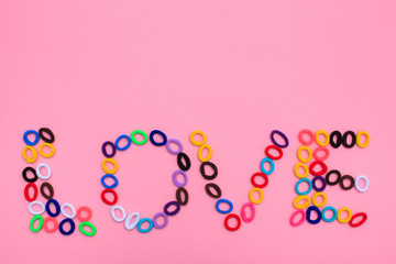 The word Love in the form of multi-colored hair elastics