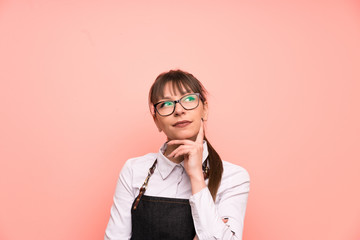 Young waitress over pink background thinking an idea