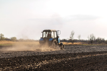 a tractor plows a field for sowing crops