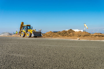 Construction site of road, building or airport with construction machinery (truck, bulldozer, excavator) and construction workers or engineers