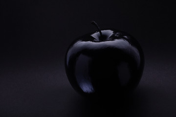 Atmospheric monochrome Art black apple on a black background, black on black Concept Mystical,...