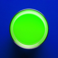 Creative template glass with green paint on colored blue paper for text. Brochure concept.