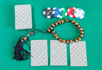 card decks, casino tokens and worry beads on table