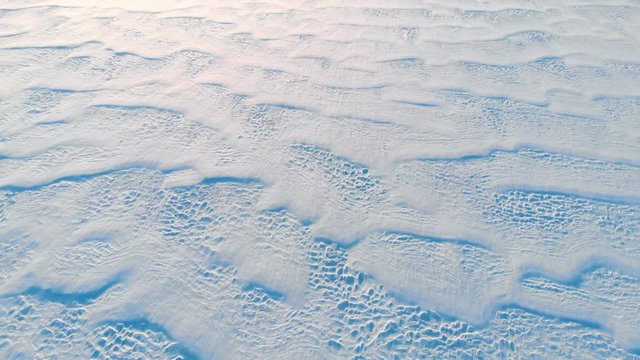 Beautiful snow winter bacground: arctic landscape at sunset, aerial view, space for text. Epic sunset above snow field. 
