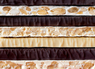 Turron. Traditional Spanish Christmas candy. Torrone and nougat with nuts. Texture, layers, background.