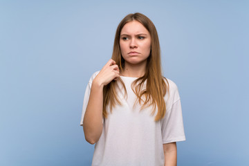 Fototapeta premium Young woman over blue wall with tired and sick expression