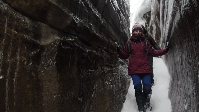 Woman backpacker in a winter hike snow forest trail national par Young girl enjoy snow falling . Happy winter holidays active lifestyle concept.
