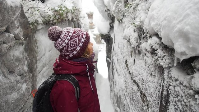 Woman backpacker in a winter hike snow forest trail national par Young girl enjoy snow falling . Happy winter holidays active lifestyle concept.
