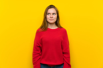 Obraz premium Young woman over yellow wall making doubts gesture looking side