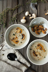 Two bowls with delicious mushroom soup on wooden table