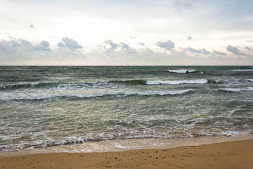 Blue and green waves with white foam on sandy beach. Black Sea, Evpatoria, Crimea, Russia. Travel, wacation concept. Text copy space.