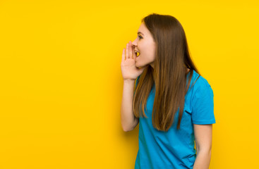 Young woman with blue shirt shouting with mouth wide open