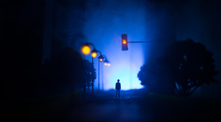 Artwork decoration. A man standing on a road of burnt up city. Apocalyptic view of city downtown as disaster film poster concept. Night scene. City destroyed by war.