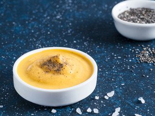 Creamy Cheddar sauce with chia seeds on dark background.Ideas and recipe for healthy diet or vegan...
