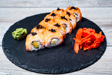 Sushi rolls on black stone plate