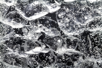 Glasstücke liegen im Wasser. An ihnen steigen Gasblasen hoch.