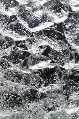 Glasstücke liegen im Wasser. An ihnen steigen Gasblasen hoch.