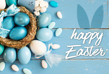 Bright blue colored Easter eggs in nest on wooden background, selective focus image. Happy Easter...