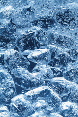 Glasstücke liegen im Wasser. An ihnen steigen Gasblasen hoch.