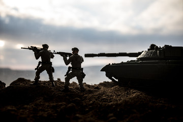 War Concept. Military silhouettes fighting scene on war fog sky background, World War Soldiers Silhouettes Below Cloudy Skyline at sunset. Attack scene. Armored vehicles.