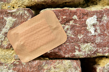 Pflaster auf defekter Backsteinmauer