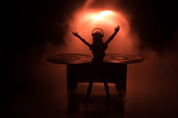 Dj club concept. Woman DJ mixing, and Scratching in a Night Club. Girl silhouette on dj's deck,...