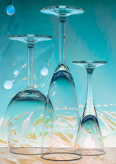 Three glasses standing upside down on a colored background