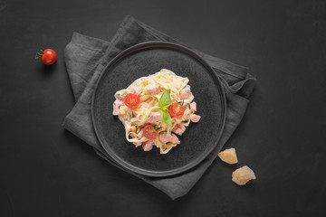 Obraz na płótnie Canvas Pasta tagliatelle with trout and cream on black background. Delicious Mediterranean lunch.