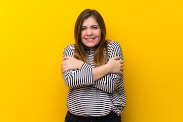 Obraz premium Young girl over yellow wall freezing