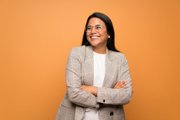 Young Colombian girl over brown wall happy and smiling