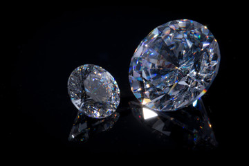 Extremely close-up of two beautiful Swarovski crystals on a deep black mirror surface, isolate.