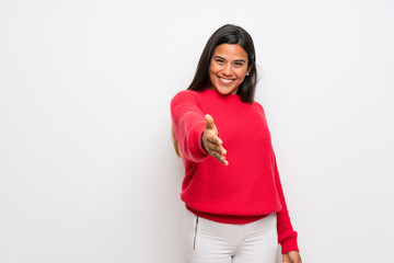 Young Colombian girl with red sweater shaking hands for closing a good deal