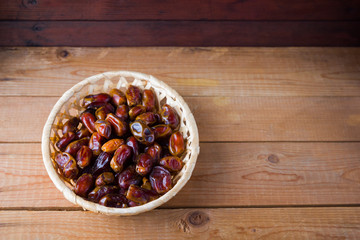 Dates on wooden background. Holy month of Ramadan, concept. Righteous Muslim lifestyle. Starvation. Dates in a wooden basket in the style of minimalism. Copy space