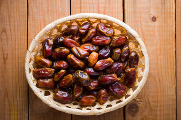 Dates on wooden background. Holy month of Ramadan, concept. Righteous Muslim lifestyle. Starvation. Dates in a wooden basket in the style of minimalism. Copy space
