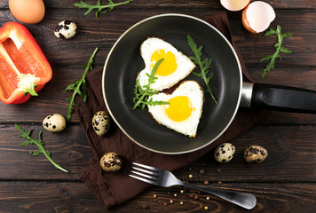 Valentines breakfast in heart shaped cast iron pan of two raw eggs and yolks