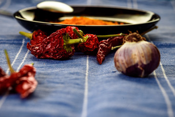 red pepper on the table, still life with garlice and  red pepper over a blue tablecloth. cooking...