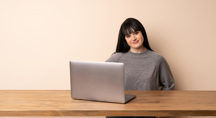 Young woman working with her laptop laughing looking to the front