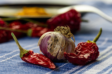 garlic and hot pepper on the table , still life with garlice and  red pepper over a blue...