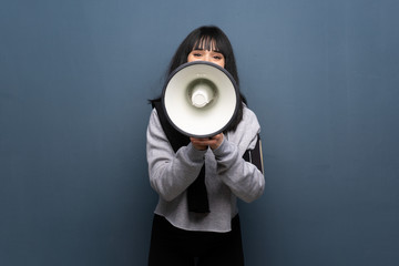 Young sport woman shouting through a megaphone