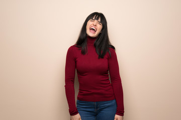 Young woman with red turtleneck shouting to the front with mouth wide open