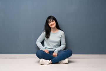 Woman sitting on the floor laughing looking to the front