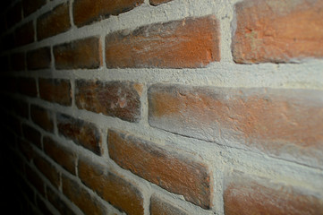 Textured wall of old brick with white seam