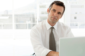 pensive businessman working on laptop in office